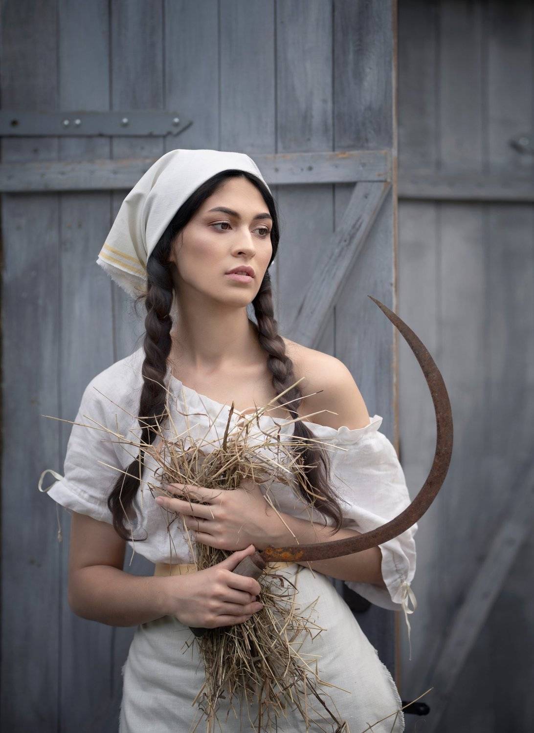 Retrato de una mujer con pañuelo blanco, trenzas y una hoz en la mano, de Evgeniya Fedorova